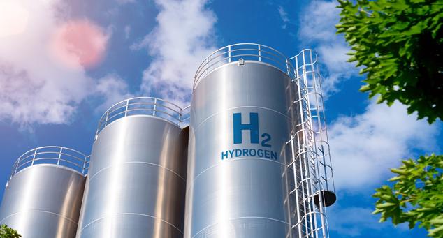 Tall hydrogen storage tanks against a blue sky