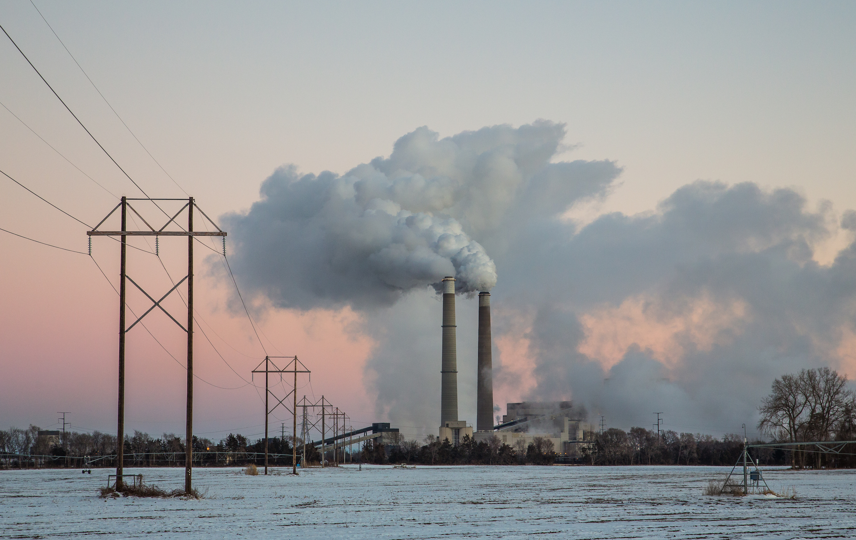 Xcel Energy's Sherburne County (Sherco) Generating Station, a coal-fired power plant, near Becker, Minnesota, shown with snow on the ground and a pink sky.