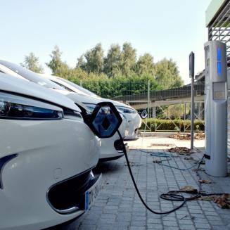 Three cars parked at electric vehicle charging stations