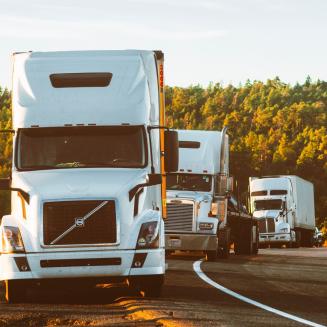 Three semi-trucks cruising down the road