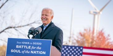 Joe Biden stands at a podium in front of a wind turbine