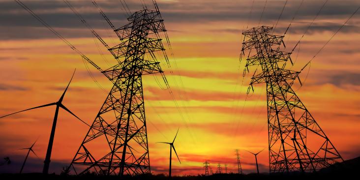 Landscape featuring electric power lines commingling with wind turbines