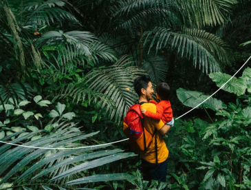 Man holding child in the middle of the rain forest