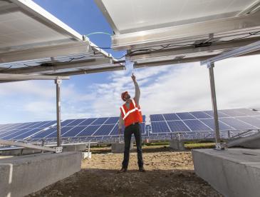 Solar photovoltaic installer examining racking for a PV array